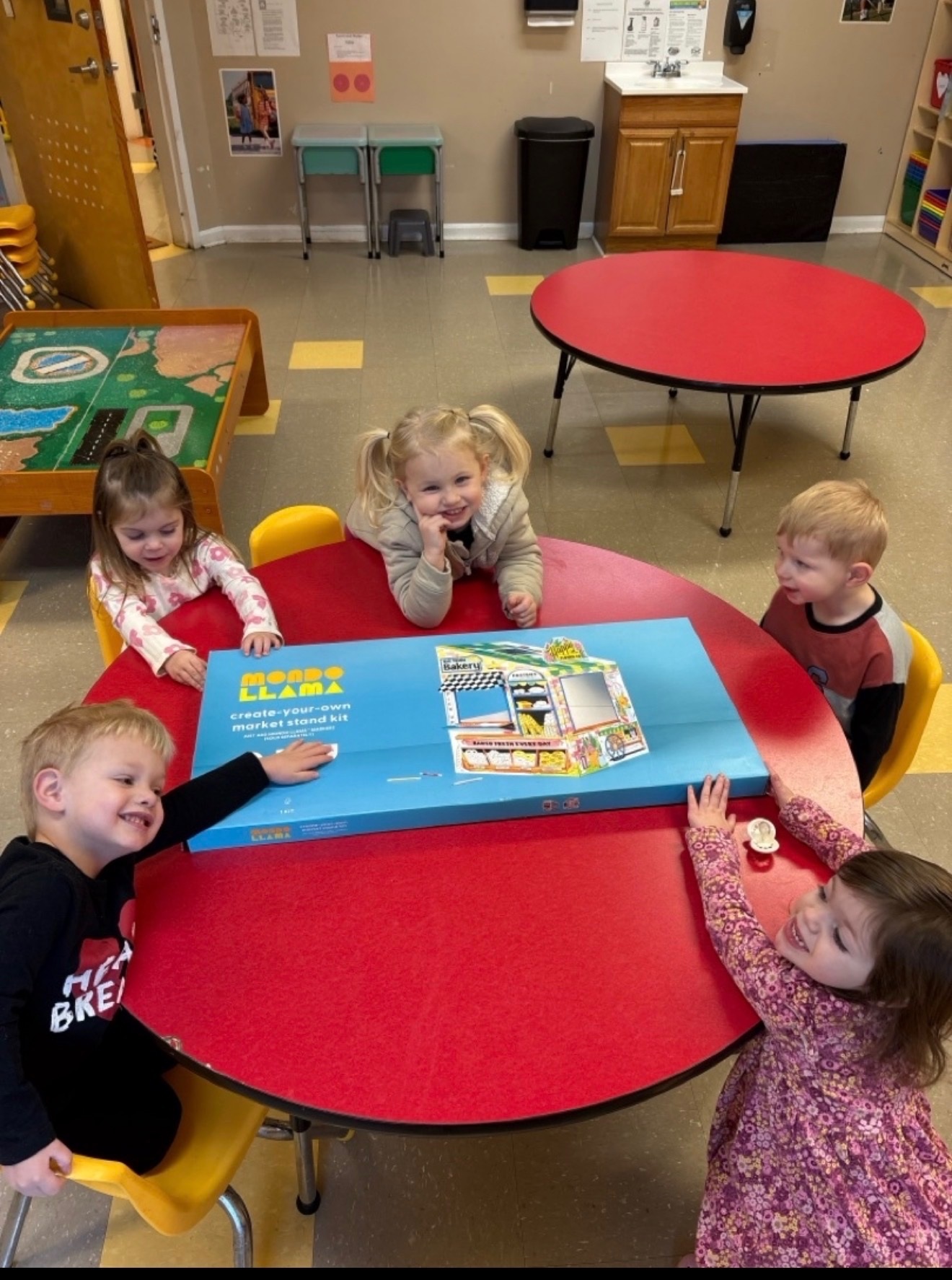 Children gathered around a classroom activity table