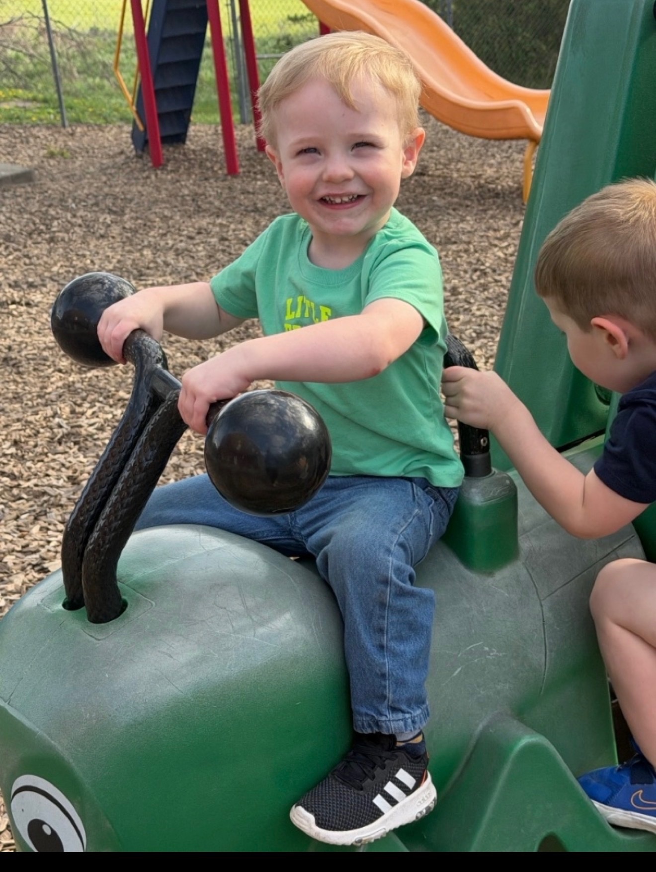 Child smiling on playground equipment