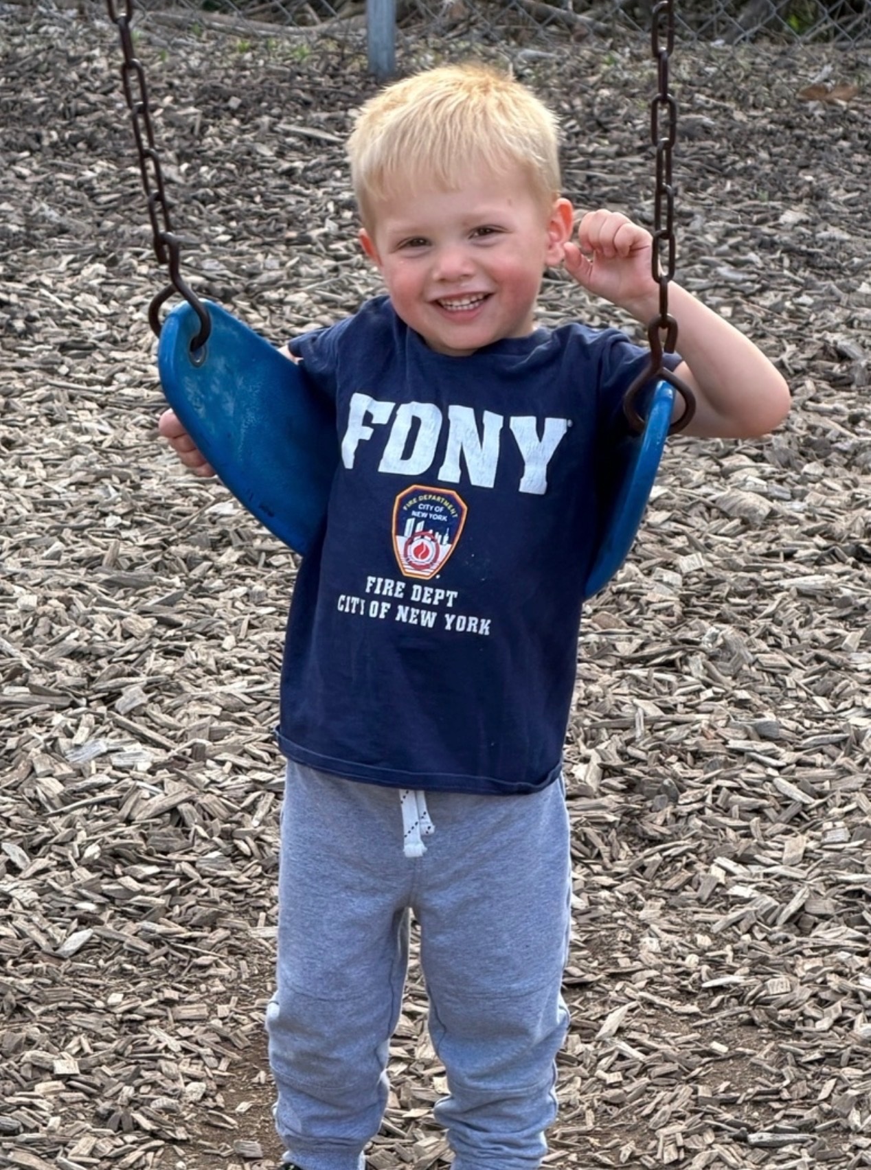 Child smiling on the playground swing
